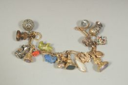 A 9CT GOLD CHARM BRACELET set with 20 various charms.