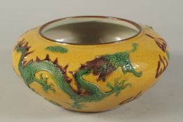 A CHINESE YELLOW GROUND CIRCULAR BOWL with dragons in relief. 10ins diameter.
