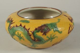 A CHINESE YELLOW GROUND CIRCULAR BOWL with dragons in relief. 10ins diameter.