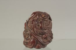 A CARVED HARDWOOD NETSUKE WITH A MAN AND DRAGON. Signed. 5cms.