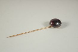 A CABOUCHON STONE HAT PIN.