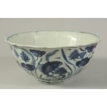 A CHINESE BLUE AND WHITE PETAL-FORM BOWL, painted with fish and aquatic flora. 22cms wide.