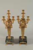 A GOOD PAIR OF THOMAS HOPE DESIGN THREE BRANCH CLASSICAL CANDLESTICKS on marble bases. 18ins high.