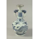 A CHINESE BLUE AND WHITE PORCELAIN TWIN-HANDLE VASE, with dragon and phoenix. 26cms high.