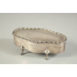 AN OVAL SILVER JEWELLERY BOX with velvet interior on four pad feet. 4ins long. Birmingham 1916.