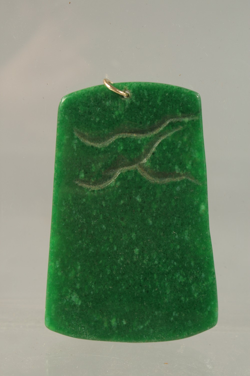 A CHINESE CARVED GREEN JADE PENDANT with gold ring. 6cms x 3.5cms. - Image 2 of 2