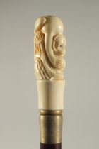 A CARVED BONE HANDLED WALKING STICK "MONKEY".