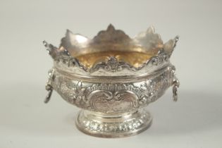 A GOOD SMALL SILVER MONTEITH BOX with repousse decoration and lion ring handles. 5.25ins diameter.