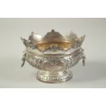 A GOOD SMALL SILVER MONTEITH BOX with repousse decoration and lion ring handles. 5.25ins diameter.