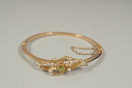 AN EDWARDIAN GOLD BANGLE set with seed pearls.