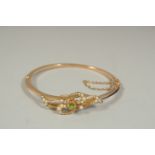 AN EDWARDIAN GOLD BANGLE set with seed pearls.