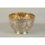 A VICTORIAN SILVER CIRCULAR BOWL repousse with flower and bead decoration. 4.25ins diameter.