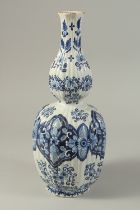 A DUTCH BLUE AND WHITE POTTERY VASE with floral panels. 14ins high.