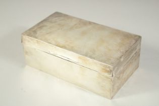 A PLAIN RECTANGULAR SILVER CIGARETTE BOX with cedarwood liner. 7ins long. London 1912