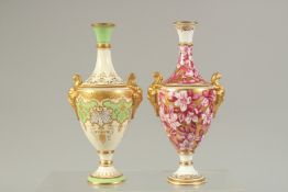 A COALPORT VASE WITH TWO MASK HEAD HANDLES, painted with crimson and white flowers, on a solid