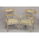 A PAIR OF CARVED, PAINTED AND PARCEL GILDED OPEN ARMCHAIRS, with floral upholstered overstuffed