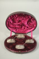 A SET OF FOUR VICTORIAN SILVER CIRCULAR SALTS AND SPOONS in a fitted case. Sheffield 1885.