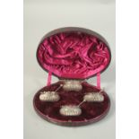 A SET OF FOUR VICTORIAN SILVER CIRCULAR SALTS AND SPOONS in a fitted case. Sheffield 1885.