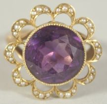 A PURPLE STONE AND SEED PEARL RING. Size M.