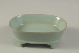 A CHINESE CELADON GLAZED RU WARE PLANTER, raised on four feet. 17cms wide.