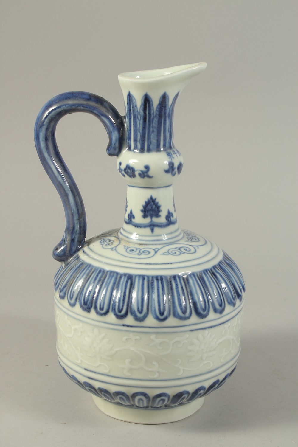 A CHINESE BLUE AND WHITE PORCELAIN EWER, with a band of carved floral decoration. 29cms high. - Image 3 of 6