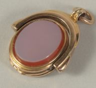 A GOLD OVAL OPENING FOB PENDANT.