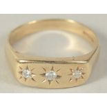 A 9CT GOLD THREE STONE DIAMOND GYPSY RING.