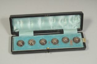 A CASED SET OF SIX BUTTONS.