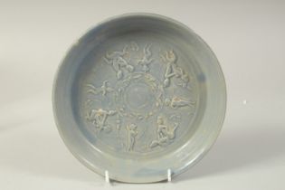 A CHINESE BLUE GLAZE POTTERY DISH, with carved erotic figures, 21cm diameter.