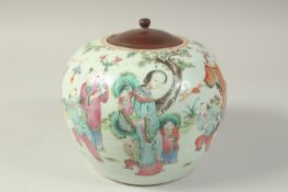 A 19TH CENTURY CHINESE FAMILLE ROSE PORCELAIN JAR AND WOODEN COVER, painted with a joyous scene of