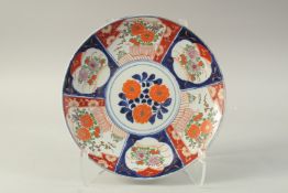 A JAPANESE IMARI PORCELAIN CHARGER, painted with panels of flora, 31.5cm diameter.