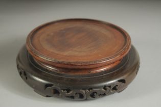 A CHINESE CARVED HARDWOOD CIRCULAR STAND, with pierced base, the stand to house a base of 14cm