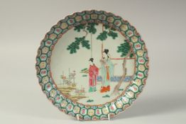 A CHINESE FAMILLE ROSE PORCELAIN PLATE, painted with female figures in a garden, the base with