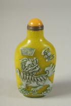 A CHINESE RELIEF-DECORATED FOO DOG SNUFF BOTTLE AND STOPPER / SPOON, 8cm high.