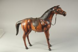 A LARGE LIBERTY'S STYLE LEATHER OVERLAID WOODEN HORSE, 56cm long.