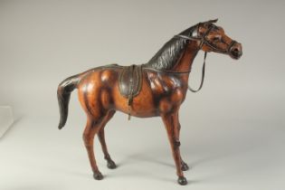 A LARGE LIBERTY'S STYLE LEATHER OVERLAID WOODEN HORSE, 56cm long.