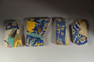 A COLLECTION OF FOUR 17TH CENTURY PERSIAN SAFAVID CUERDA SECA GLAZED POTTERY TILES, largest 31cm