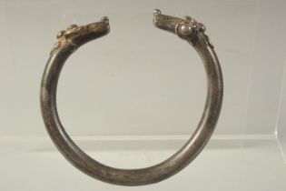 A MIDDLE EASTERN POSSIBLY SELJUK PERIOD SILVER ANKLET, with two head-form terminals.