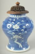 A LARGE CHINESE BLUE AND WHITE PORCELAIN PRUNUS JAR, with carved and pierced hardwood cover, jar