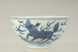 A CHINESE BLUE AND WHITE PORCELAIN BOWL, decorated with beasts above a band of waves, the base