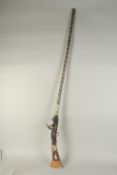 AN EARLY 20TH CENTURY NORTH AFRICAN MOROCCAN BONE AND WHITE METAL INLAID MUSKET, 160cm long.