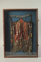 AN EARLY 20TH CENTURY PALESTINIAN BURQA WITH SILVER COINS, mounted within a glazed wooden display