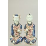 A PAIR OF CHINESE UNDERGLAZE RED AND BLUE PORCELAIN CHILD FIGURES, 23cm high.