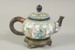 A CHINESE FINELY ENAMELLED TEAPOT ON BRONZE STAND, intricately painted with panels of flora and