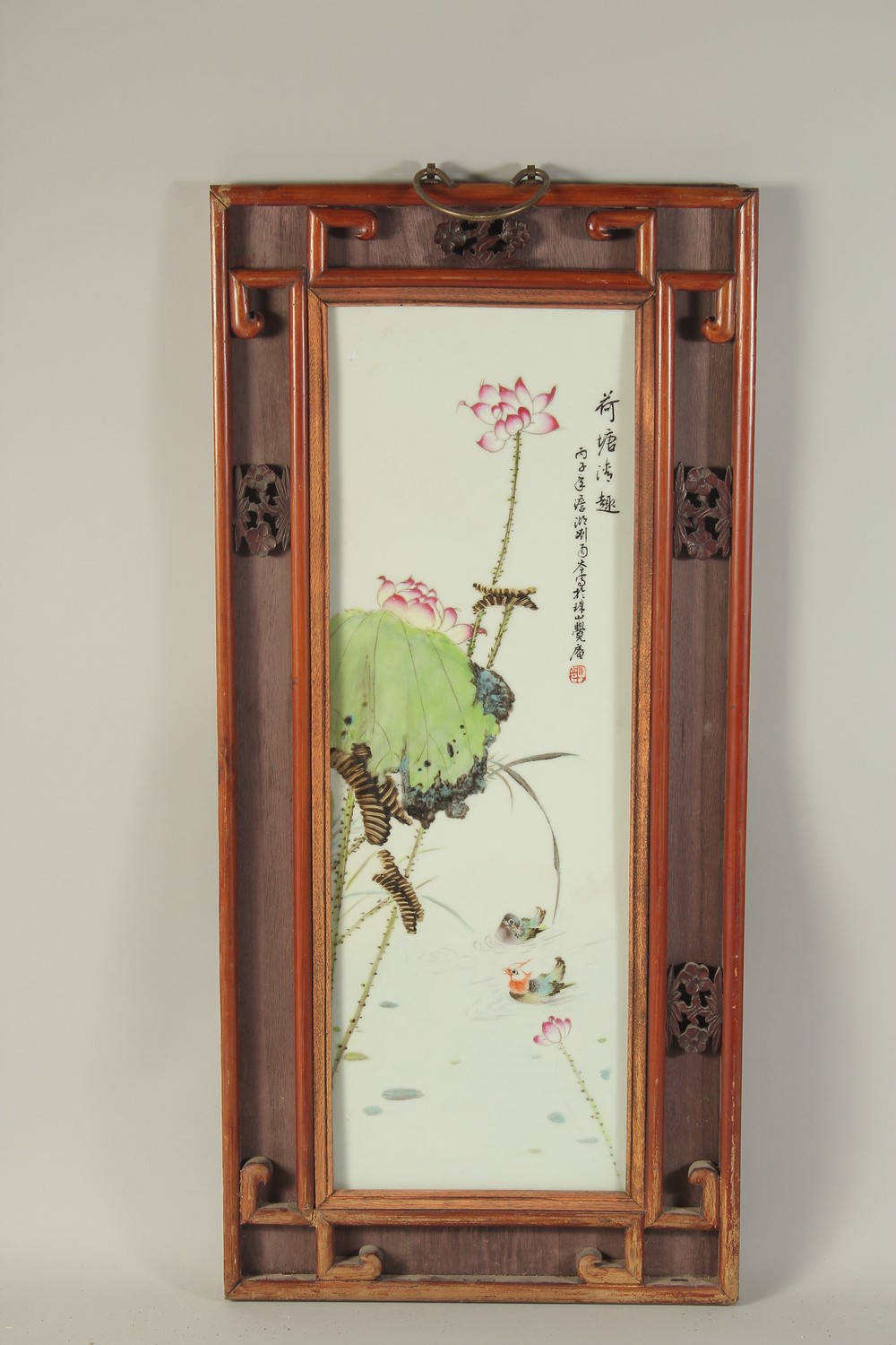 A CHINESE FAMILLE ROSE PORCELAIN PLAQUE, inset within a wooden frame, panel 56cm x 19cm.