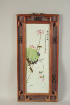 A CHINESE FAMILLE ROSE PORCELAIN PLAQUE, inset within a wooden frame, panel 56cm x 19cm.