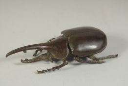 A BRONZE OKIMONO OF A RHINOCEROS BEETLE, with hinged lid, 10.5cm long.