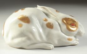 A JAPANESE KUTANI PORCELAIN HARE, with gilded patches and painted red eyes, made in Japan mark, 22cm