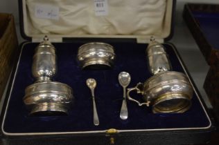 A cased set of silver condiments.
