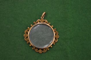 A yellow metal circular portrait miniature frame/pendant.